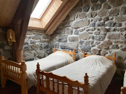 a bedroom with two beds in a stone wall at Ciel d'Ardeche in Lachamp-Raphaël