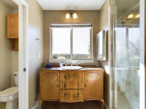 uma casa de banho com um lavatório e uma janela em Cozy Casa - Wine Country Family Retreat em Paso Robles