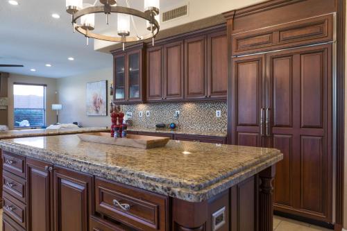 a kitchen with wooden cabinets and a granite counter top at Desert Paradise Pool Spa Pickleball Putt Green in Phoenix