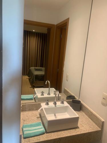 a bathroom with two sinks and a large mirror at Flat com Ótima infraestrutura in Rio de Janeiro