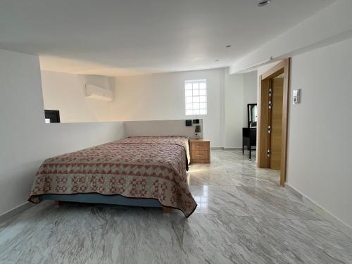 a bedroom with a bed and a desk and a window at Casa Bianca in Kavala