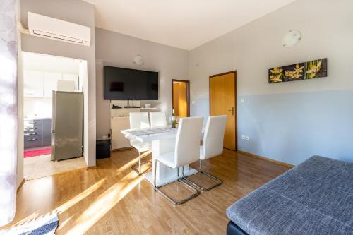 - un salon avec une table et des chaises blanches dans l'établissement Apartments Niki, à Pula