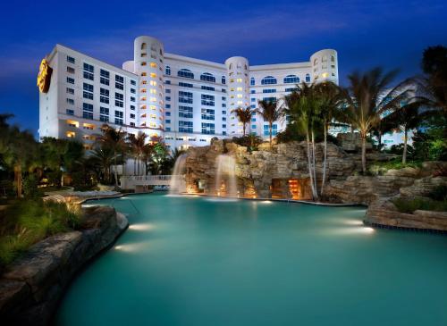 a pool in front of a hotel at night at Seminole Hard Rock Hotel & Casino Hollywood in Fort Lauderdale