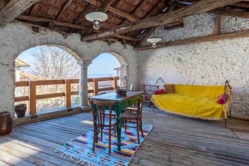 a room with a table and chairs and a bed at DA TINTI in Madonna del Sasso