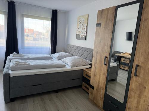 1 dormitorio con cama y espejo grande en Hotel Rademacher, en Wittmund