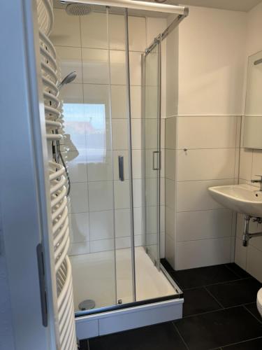 uma casa de banho com um chuveiro e um lavatório. em Hotel Rademacher em Wittmund