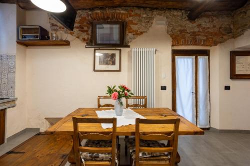 a dining room table with a vase of flowers on it at DA TINTI in Madonna del Sasso