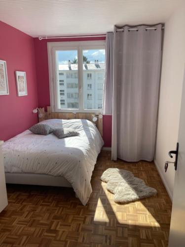une chambre avec un lit et une grande fenêtre dans l'établissement Grand appartement cosy 4ch, à Cholet