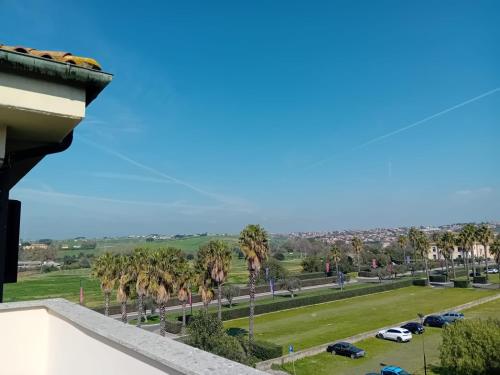 a view of a park with palm trees and cars at HOUSE MAGIE 2 e 3 in Marco Simone