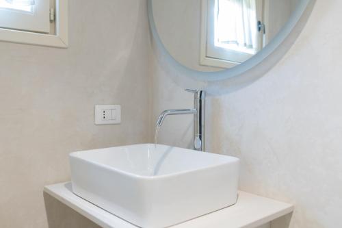 a white sink in a bathroom with a mirror at La Casèdde in Cisternino