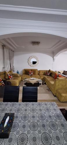 a living room with couches and a table at Super Cozy Apartment in Larache