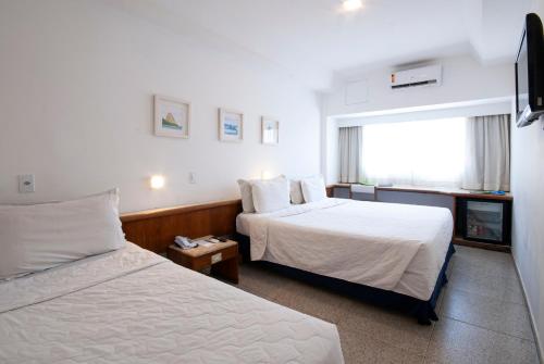 Habitación de hotel con 2 camas y ventana en Hotel Bandeirantes en Río de Janeiro