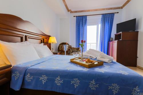 a hotel room with a bed with a tray of food on it at Kymata in Paralia Katerinis