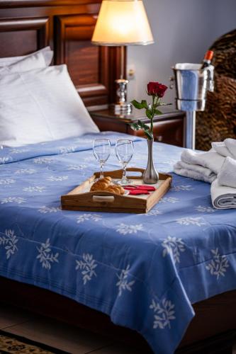 a tray with two wine glasses and a flower on a bed at Kymata in Paralia Katerinis