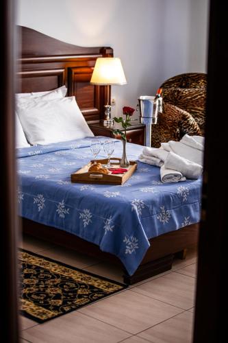 a bedroom with a blue bed with a tray with wine glasses at Kymata in Paralia Katerinis