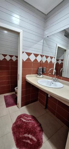 a bathroom with a sink and a mirror at Super Cozy Apartment in Larache