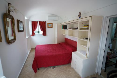 カプリにあるLa Casa Dei Merliの小さなベッドルーム(赤いベッド付)