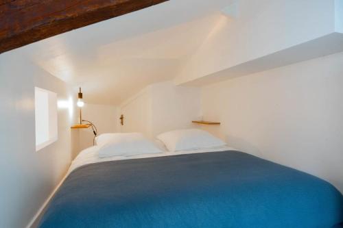 a bedroom with a large bed with a blue blanket at Appartement Porte de Versailles in Malakoff