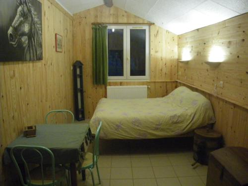 une chambre avec un lit, une table et des chaises dans l'établissement Chambre triple du grand sapin, à Chaudenay