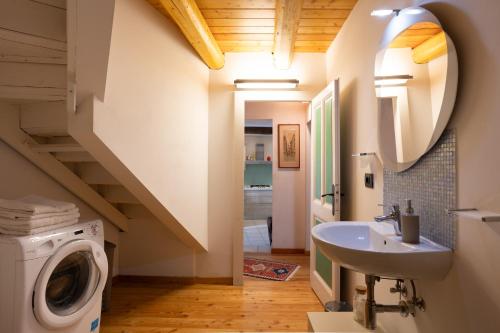 a bathroom with a washing machine and a sink at Dal Picasass House in Madonna del Sasso