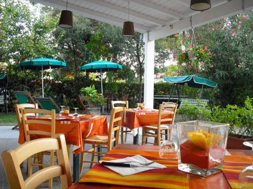 een restaurant met tafels en stoelen met parasols bij Hotel Garden in Tirrenia