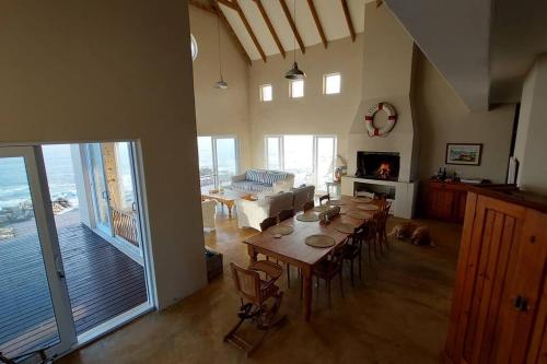 a dining room with a table and a living room with a dog at Rusenvrede Self Catering in Cape St Francis
