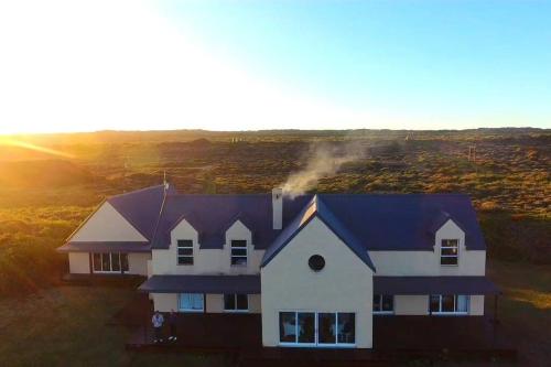 an aerial view of a house with the sun setting at Rusenvrede Self Catering in Cape St Francis