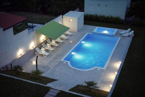 a large swimming pool with lounge chairs at Villa HS in Mostar