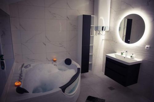 Baño blanco con bañera y lavamanos en Villa HS, en Mostar