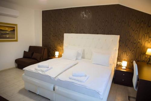 a bedroom with a large white bed with two towels at Villa HS in Mostar