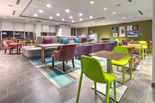 a restaurant with colorful chairs and tables and a couch at Home2 Suites By Hilton Tulsa Airport in Tulsa