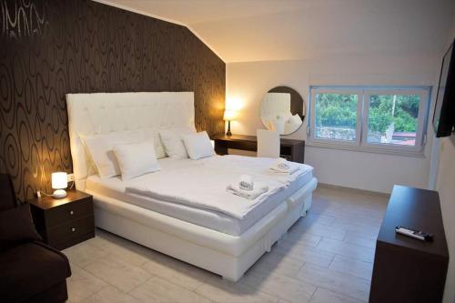 Un dormitorio con una gran cama blanca y una ventana en Villa HS, en Mostar
