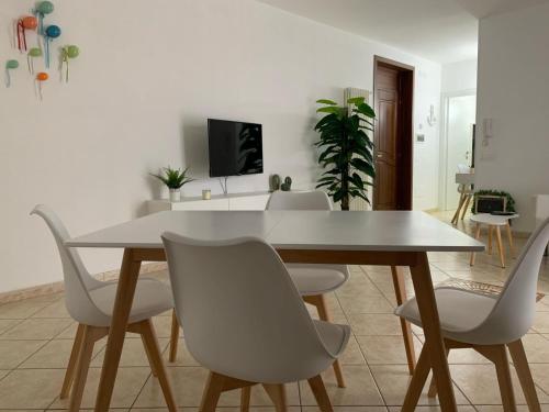 une salle à manger avec une table et des chaises blanches dans l'établissement Alemà casa vacanze, à Leporano