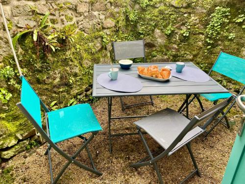 een tafel met stoelen en een kom eten erop bij Les Volets Blancs in Dinan