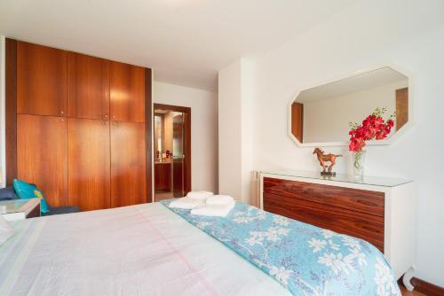 a bedroom with a bed with a dresser and a mirror at Apartment Qian Rio Douro 2BR Free Parking in Porto