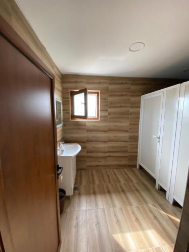 a bathroom with wooden walls and a sink and a toilet at Vikendica za odmor Laktasi in Laktaši