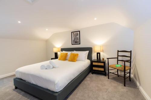 a bedroom with a large bed with yellow pillows at The Piano Cottage in a Beautiful Medieval Town in Market Bosworth