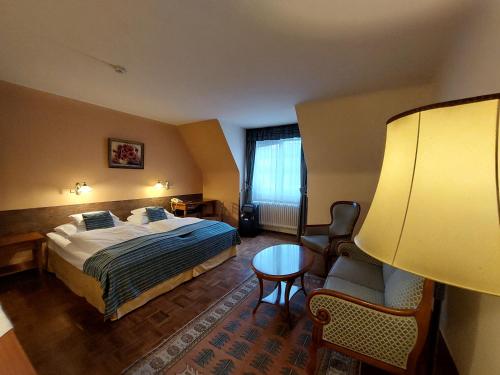 ウィーンにあるホテル アパートメント ローゼンスタイナーのベッド、テーブル、椅子が備わるホテルルームです。
