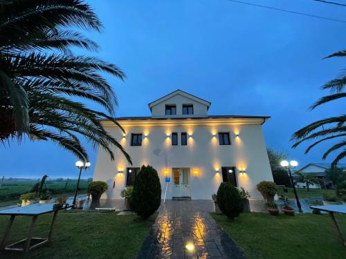 a white house with palm trees in front of it at Hotel Mi Norte in Ribadeo