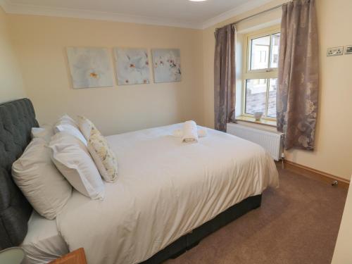 Nook Cottage في ألنويك: غرفة نوم بسرير ومخدات بيضاء ونافذة