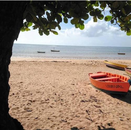 Ap202 Vista Praia de Bicanga في سيرا: وجود قارب احمر على شاطئ رملي
