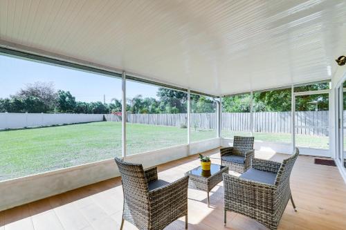 a screened in porch with chairs and a table at Valrico Home with Yard about 14 Mi to Downtown Tampa in Valrico
