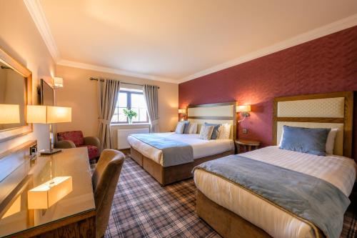 Pokój hotelowy z 2 łóżkami i biurkiem w obiekcie Flagstaff Lodge w mieście Newry