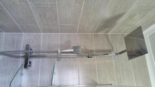 einem Duschvorhang im Bad mit Metallstange in der Unterkunft 2BR Cottage Swimming Pool Near Airport in Harare