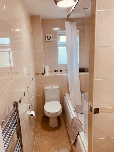 La salle de bains est pourvue de toilettes et d'une baignoire. dans l'établissement 2 bedroom house walking distance to city centre WITH FREE PARKING, à York