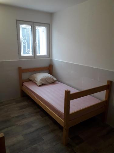 - une petite chambre avec un lit et une fenêtre dans l'établissement 143 VH, au Blanc-Mesnil
