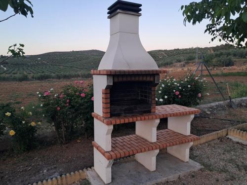 a small brick oven sitting on top of a garden at casa rural Hachuelo in Montefrío
