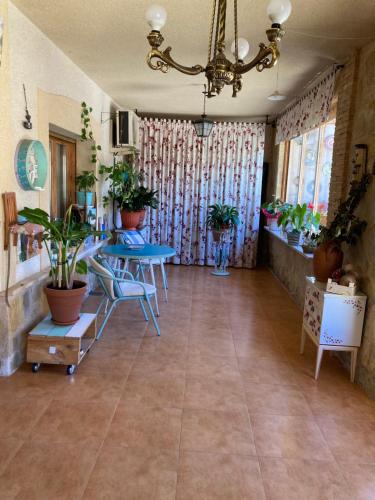 une pièce avec deux tables et des plantes en pot dans l'établissement Casa El Sol, à Mota del Cuervo