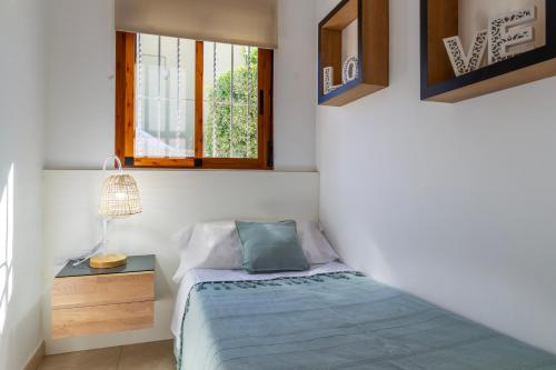 een kleine slaapkamer met een bed en een raam bij Playa de Oliva, La Casita del mar in Oliva