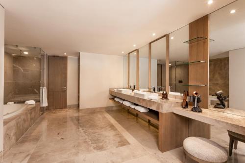 łazienka z 2 umywalkami, wanną i dużym lustrem w obiekcie Grand Velas Boutique Hotel w mieście San José del Cabo